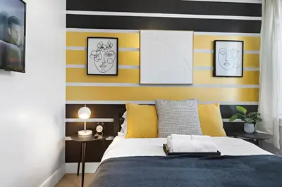 a bedroom with a bed with yellow and black stripes at 1A Prime Area Near NYC and EWR 98 Walk score in Newark