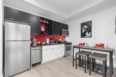 a kitchen with a stainless steel refrigerator and a table at 2C - Parking Cred, Early CI, King Bed, Sleeps 6 - 30mins to NYC in Newark