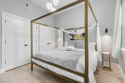 a bedroom with a canopy bed in a white room at 2C - Parking Cred, Early CI, King Bed, Sleeps 6 - 30mins to NYC in Newark