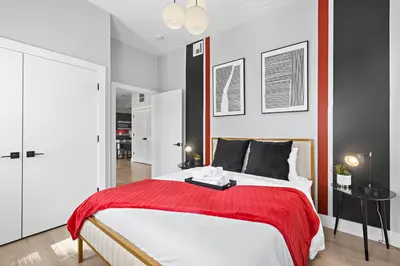 a bedroom with a large bed with a red blanket at 1C - Ask About 20Off - Sleeps 5 - Airport 8min - NYC 30min in Newark