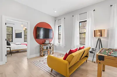 a living room with a yellow couch and a tv at 1C - Ask About 20Off - Sleeps 5 - Airport 8min - NYC 30min in Newark