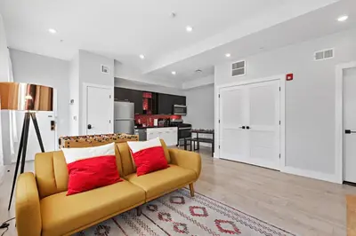 a living room with a yellow couch and a kitchen at 1C - Ask About 20Off - Sleeps 5 - Airport 8min - NYC 30min in Newark