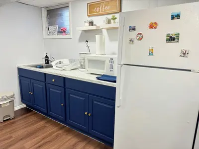 a kitchen with blue cabinets and a white refrigerator at Cozy 1 bedroom close to NYC with private bar in North Bergen