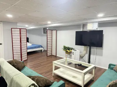 a living room with a couch and a flat screen tv at Cozy 1 bedroom close to NYC with private bar in North Bergen
