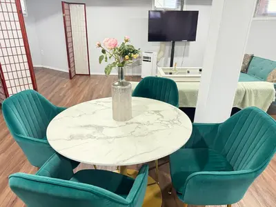 a table with chairs and a vase with flowers on it at Cozy 1 bedroom close to NYC with private bar in North Bergen