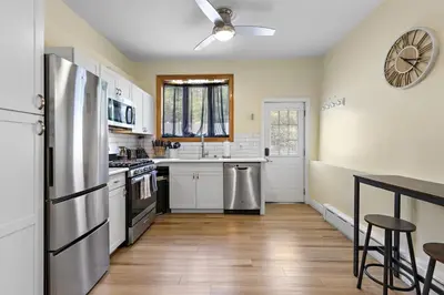 a kitchen with white cabinets and a refrigerator at Cozy Apartment with Max Comfort in Bayonne