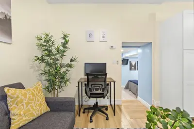 a living room with a chair and a desk with a computer at Cozy Apartment with Max Comfort in Bayonne