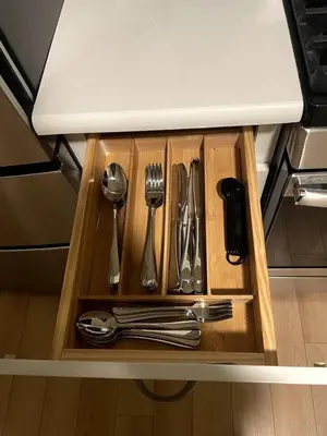 a wooden drawer with silver utensils in a kitchen at Cozy Apartment with Max Comfort in Bayonne
