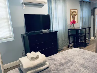 a bedroom with a tv and towels on a bed at Rittenhouse Square close by Kimmel Center Suite in Philadelphia