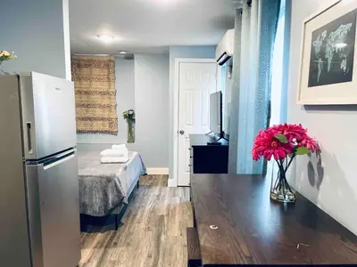 a small room with a bed and a vase of flowers at Rittenhouse Square close by Kimmel Center Suite in Philadelphia