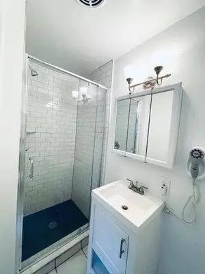 a white bathroom with a shower and a sink at Rittenhouse Square close by Kimmel Center Suite in Philadelphia