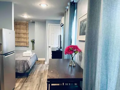 a room with a table with a vase of flowers on it at Rittenhouse Square close by Kimmel Center Suite in Philadelphia