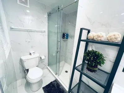 a bathroom with a glass shower and a toilet at Luxe City Hall Suite by Rittenhouse Square in Philadelphia