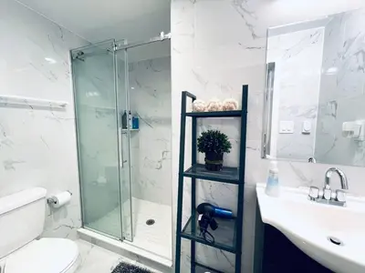 a bathroom with a glass shower and a sink at Luxe City Hall Suite by Rittenhouse Square in Philadelphia