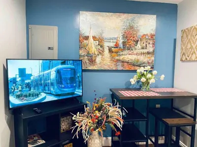 a living room with a tv and a painting on the wall at Luxe City Hall Suite by Rittenhouse Square in Philadelphia