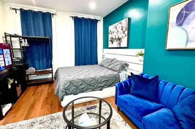 a blue living room with a couch and a bed at New - Suite by Rittenhouse Square in Philadelphia