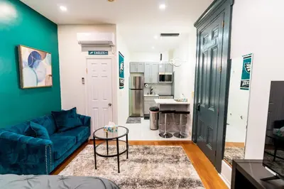 a living room with a blue couch and a table at New - Suite by Rittenhouse Square in Philadelphia