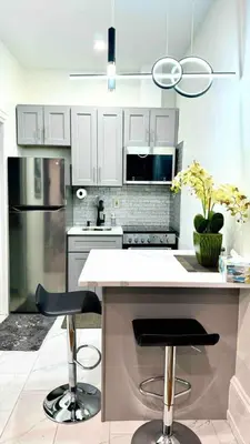 a kitchen with a counter and two bar stools at New - Suite by Rittenhouse Square in Philadelphia