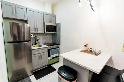 a kitchen with a stainless steel refrigerator and white cabinets at New - Suite by Rittenhouse Square in Philadelphia