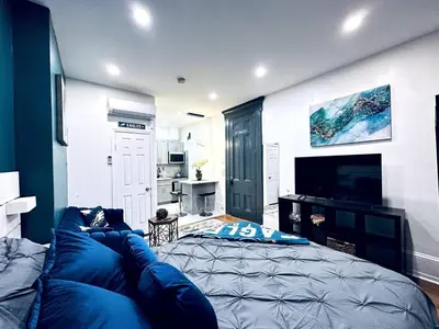 a living room with a blue couch and a television at New - Suite by Rittenhouse Square in Philadelphia
