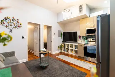 a living room with a couch and a kitchen at Downtown City Hall near Kimmel Center 2BD Suite in Philadelphia