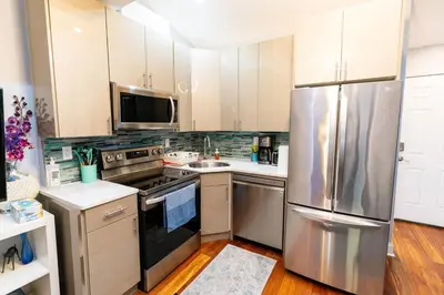 a kitchen with stainless steel appliances and white cabinets at Downtown City Hall near Kimmel Center 2BD Suite in Philadelphia
