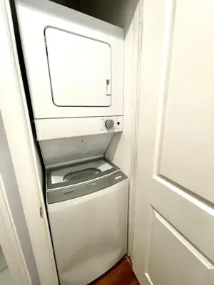 a washer and dryer in a room next to a door at Downtown City Hall near Kimmel Center 2BD Suite in Philadelphia