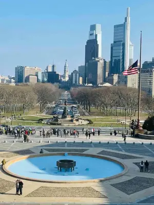 a group of people walking around a fountain in a park at Downtown City Hall near Kimmel Center 2BD Suite in Philadelphia
