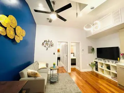 a living room with a couch and a tv at Downtown City Hall near Kimmel Center 2BD Suite in Philadelphia