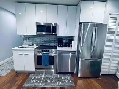 a kitchen with stainless steel appliances and white cabinets at Downtown City Hall close by Kimmel Center 1BD in Philadelphia