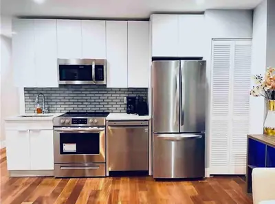 a kitchen with stainless steel appliances and white cabinets at Downtown City Hall close by Kimmel Center 1BD in Philadelphia