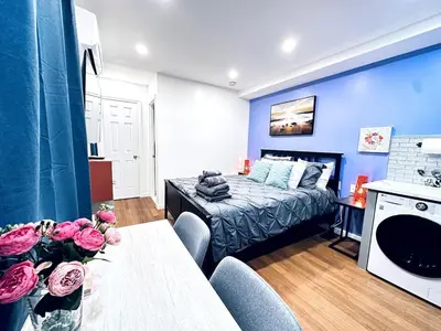 a room with a bed and a table with flowers on it at New - Suite nearby Rittenhouse Square in Philadelphia
