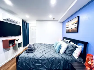 a bedroom with a bed and a flat screen tv at New - Suite nearby Rittenhouse Square in Philadelphia
