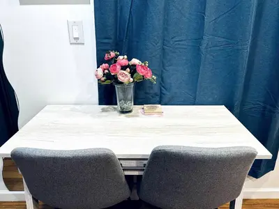 a table with a vase of flowers and two chairs at New - Suite nearby Rittenhouse Square in Philadelphia
