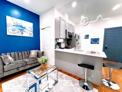a living room with a couch and a kitchen at NEW - 1 Bedroom near Rittenhouse Square in Philadelphia