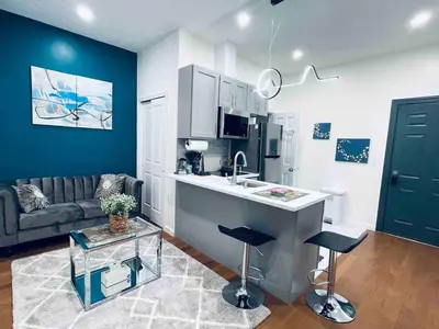 a kitchen and living room with a sink and a couch at NEW - 1 Bedroom near Rittenhouse Square in Philadelphia