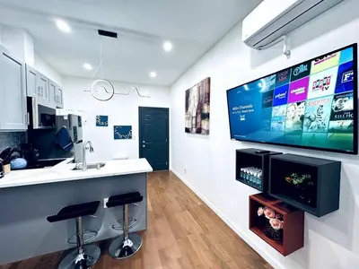 a kitchen with a large flat screen tv on a wall at NEW - 1 Bedroom near Rittenhouse Square in Philadelphia