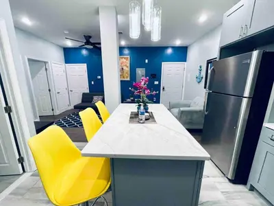 a kitchen with a table with yellow chairs and a refrigerator at Stunning 1Bedroom Apartment in Center City in Philadelphia