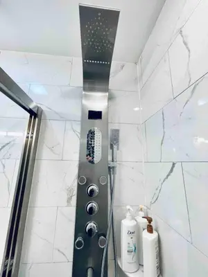 a shower in a bathroom with white marble walls at Stunning 1Bedroom Apartment in Center City in Philadelphia
