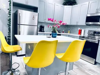 a kitchen with yellow chairs and a kitchen island at Stunning 1Bedroom Apartment in Center City in Philadelphia