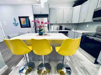 a kitchen with yellow chairs and a kitchen island at Stunning 1Bedroom Apartment in Center City in Philadelphia