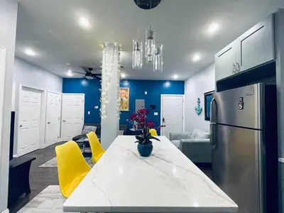 a kitchen with a white table and yellow chairs at Stunning 1Bedroom Apartment in Center City in Philadelphia