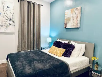 a bedroom with blue walls and a bed with pillows at Magic Gardens 2BD Apt in Center City in Philadelphia