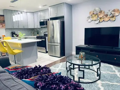 a kitchen and living room with a couch and a table at Magic Gardens 2BD Apt in Center City in Philadelphia