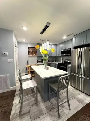 a kitchen with a table and chairs and a refrigerator at Magic Gardens 2BD Apt in Center City in Philadelphia