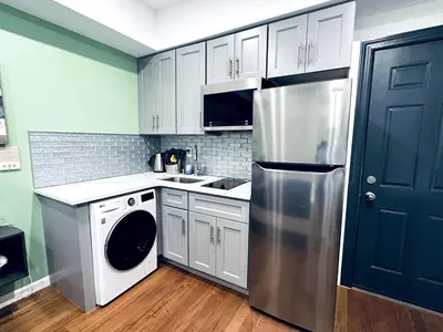 a kitchen with white cabinets and a stainless steel refrigerator at New - Suite close by Rittenhouse Square in Philadelphia