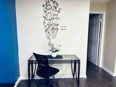 a glass desk with a chair and a vase on it at Lovely 1BD Apt Near Magic Garden in Center City in Philadelphia