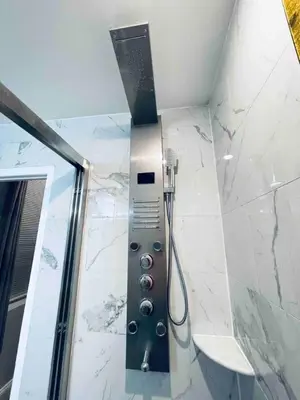 a shower in a bathroom with white marble walls at Lovely 1BD Apt Near Magic Garden in Center City in Philadelphia