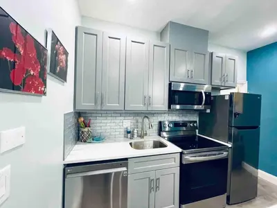 a kitchen with white cabinets and a black refrigerator at Rittenhouse Square near Kimmel Center 1BD in Philadelphia