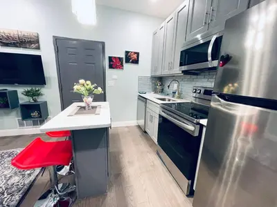 a kitchen with stainless steel appliances and a red stool at Rittenhouse Square near Kimmel Center 1BD in Philadelphia